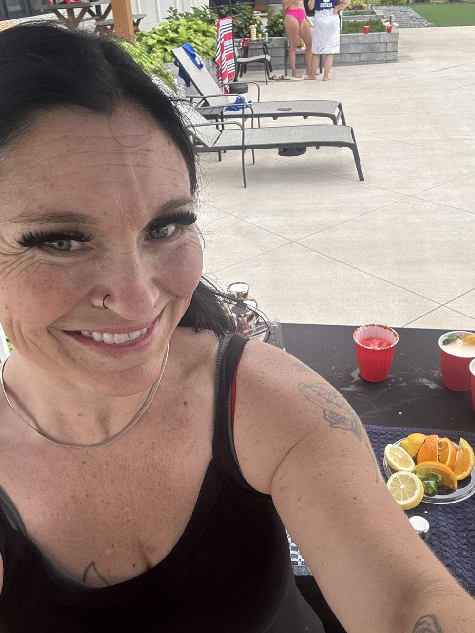 Mandy smiling behind her bar station with fresh citrus garnishes ready